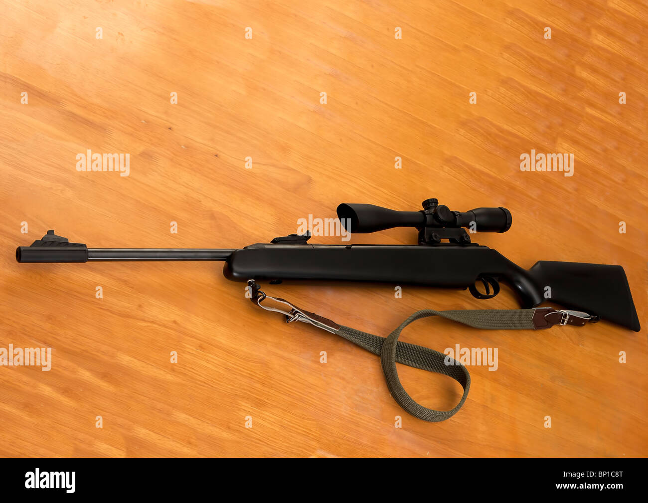 Black rifle with telescopic sights on a wooden table Stock Photo Alamy