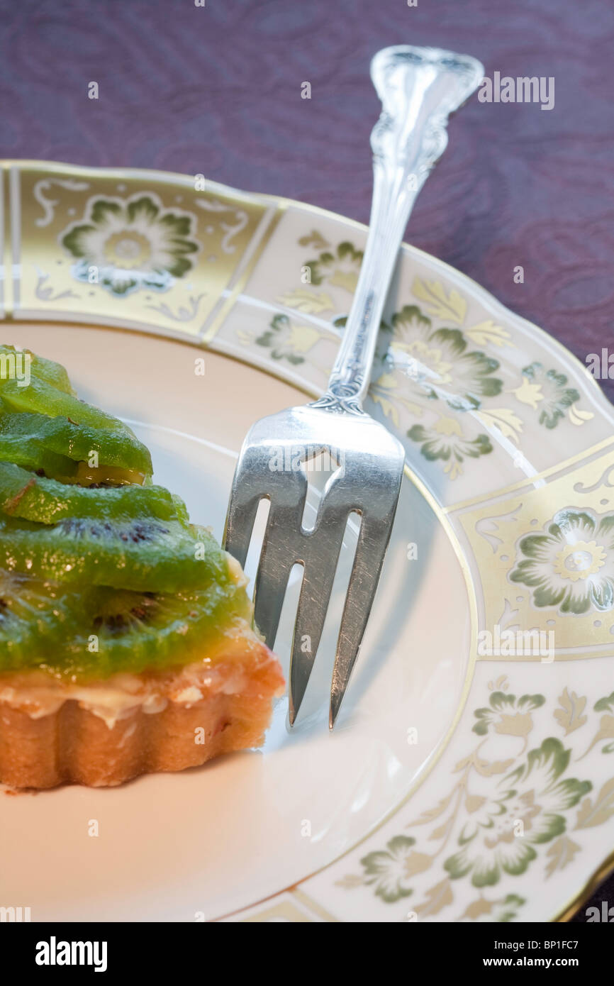 Serving of Kiwi Torte on China Plate with Sterling Silver Fork Stock Photo