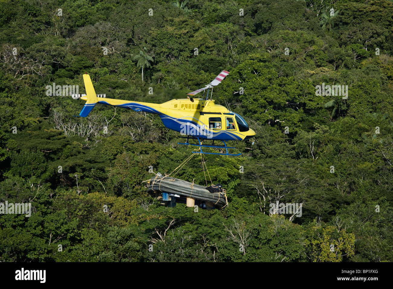 Helicopter transporting mining equipment for miners working in the Venezuela forest Stock Photo