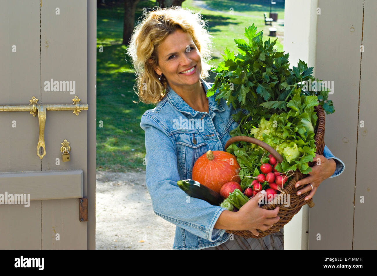 Woman holding a basket of vegetables Stock Photo - Alamy
