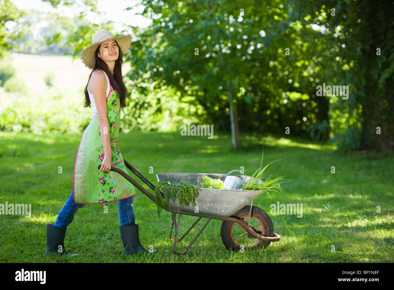 Young woman pushing wheelbarrow Stock Photo