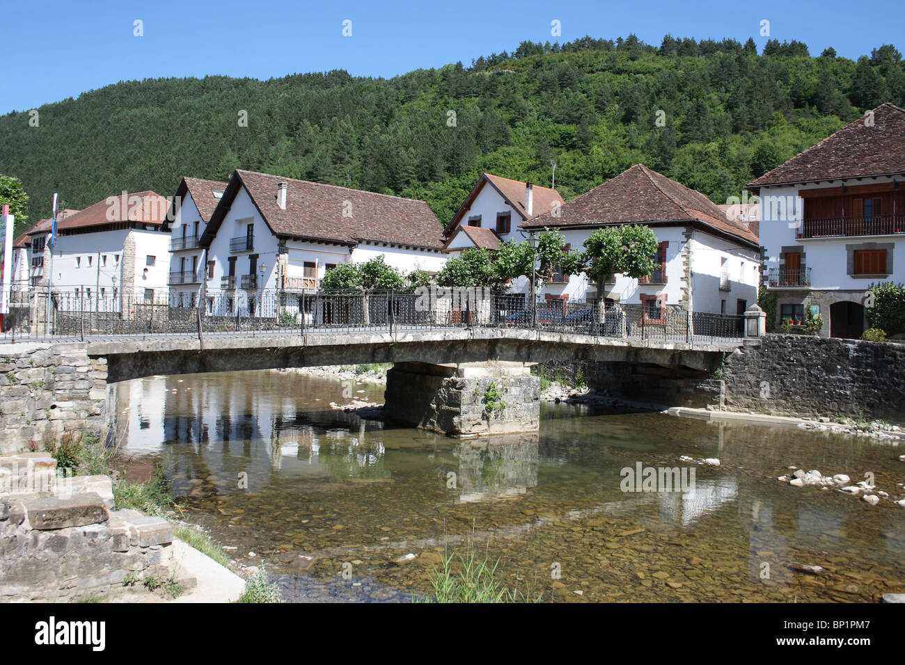 Stone Bridge in the whitewashed town of Ochagavia, on the Rio Zatoya, in the wooded hillsides of the Pyrenees, Navarra, Spain Stock Photo
