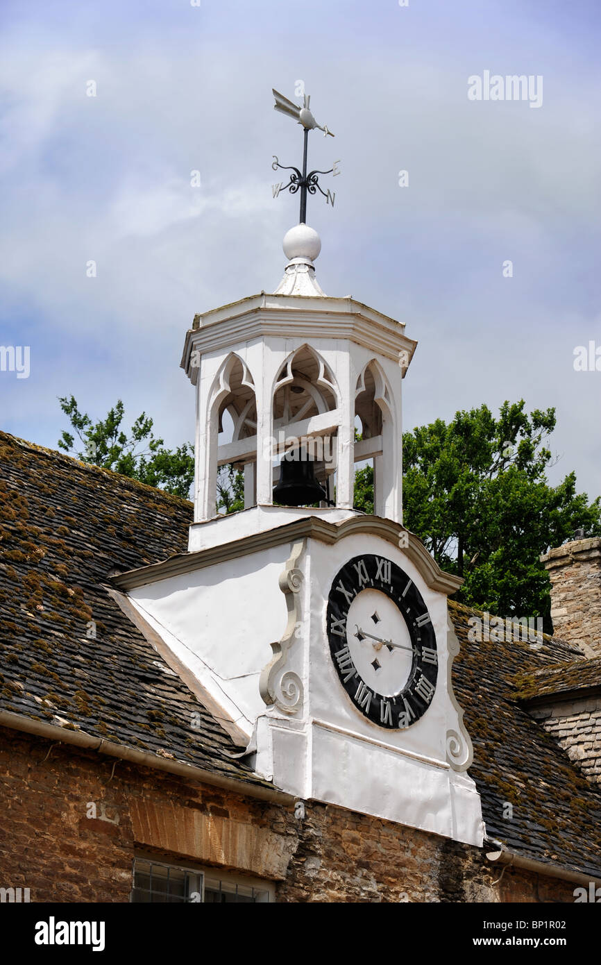 A bell tower with a clock and weather vane above the stable yard at Pusey House, Oxfordshire UK Stock Photo