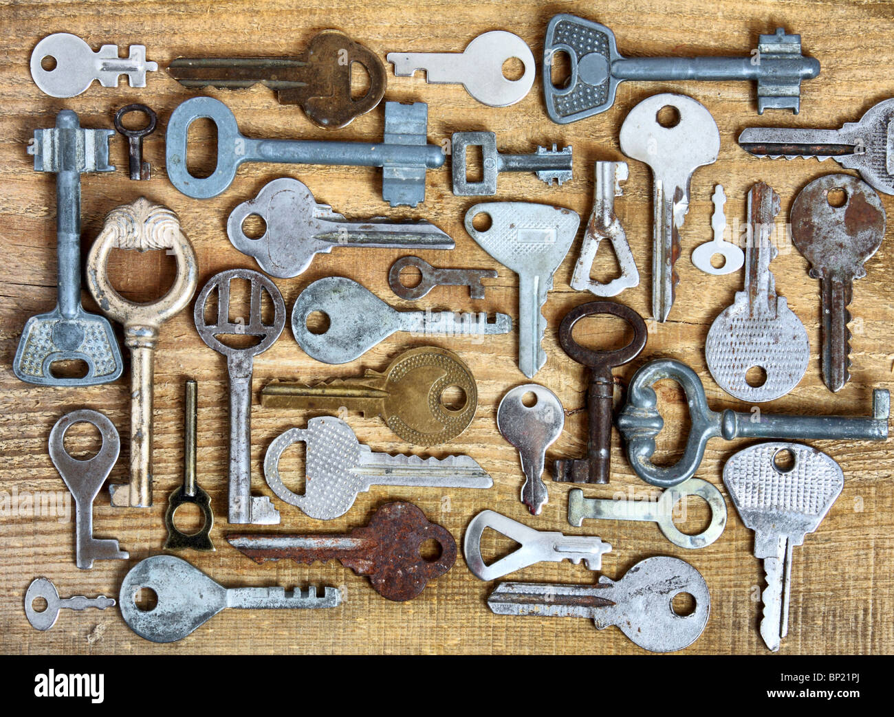 Old different keys on wooden background Stock Photo