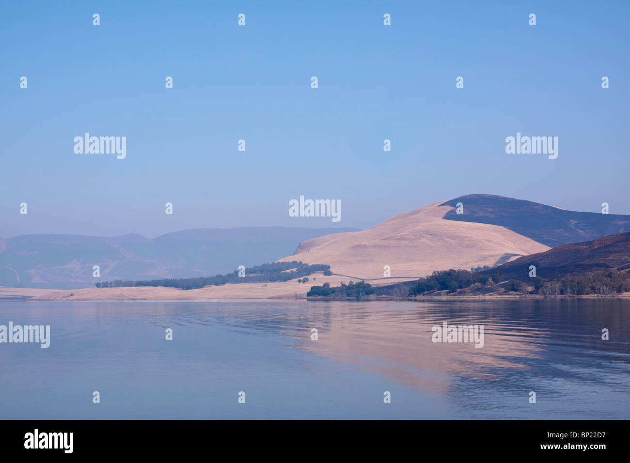Distant hills reflected in the Midmar dam on a cloudless winter day. Midlands, KwaZulu Natal, South Africa. Stock Photo