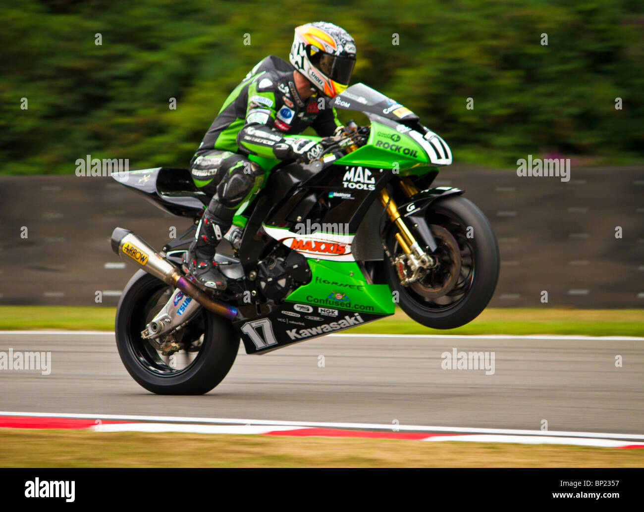Simon Andrews of MSS COLCHESTER superbike race team on his KAWASAKI  NInja  ZX-10R pulling a wheelie at Brands Hatch GP Circuit. Stock Photo