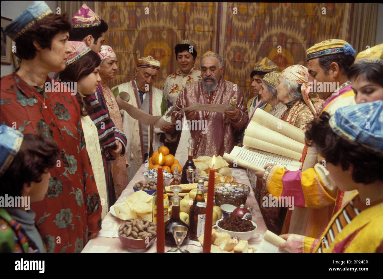 534. PURIM - JEWS FROM BUKHARA IN THEIR TRADITIONAL DRESS, READ THE PURIM SCROLL. NOTE THE FESTIVE TABLE SPREAD Stock Photo