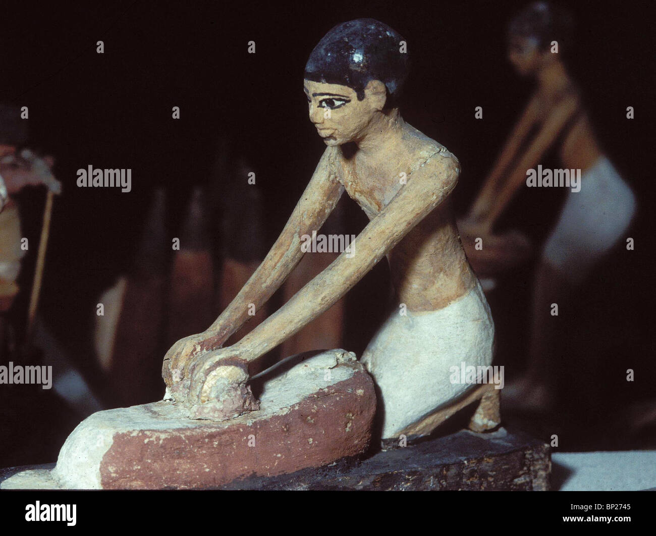 1446. WOODEN FIGURINE REPRESENTING A SERVANT GIRL GRINDING GRAIN, EGYPY, THE OLD KINGDOM, C. 2300 B.C. Stock Photo