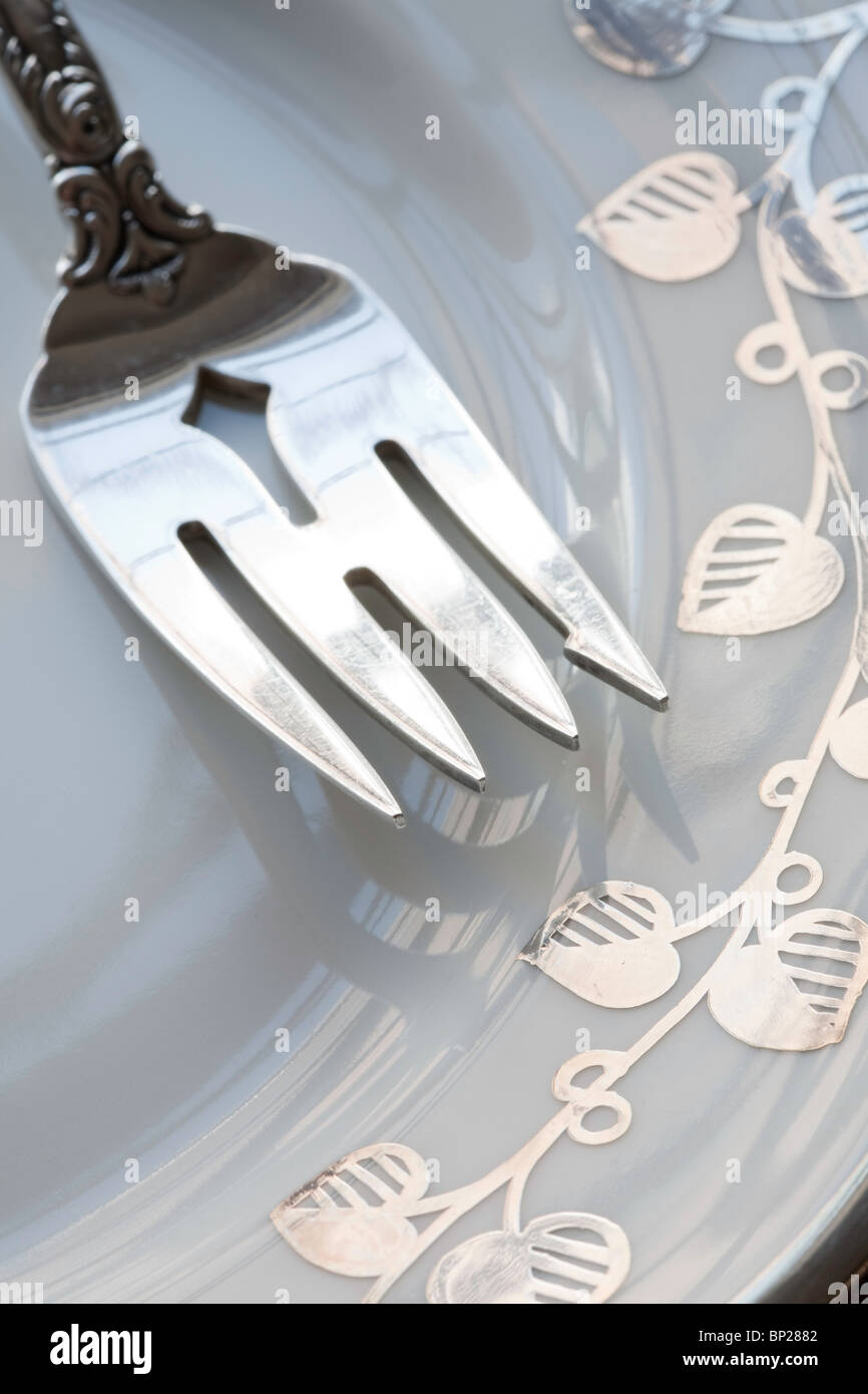 Close up of Fork Tines on China Plate Stock Photo