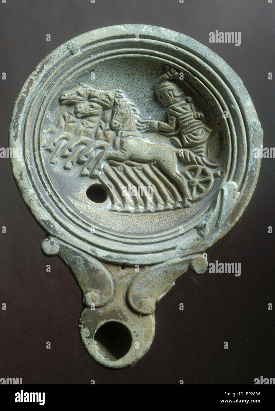 1937. DECORATED ROMAN PERIOD OIL-LAMP DEPICTING A RACING CARRIAGE WITH FOUR HORSES Stock Photo