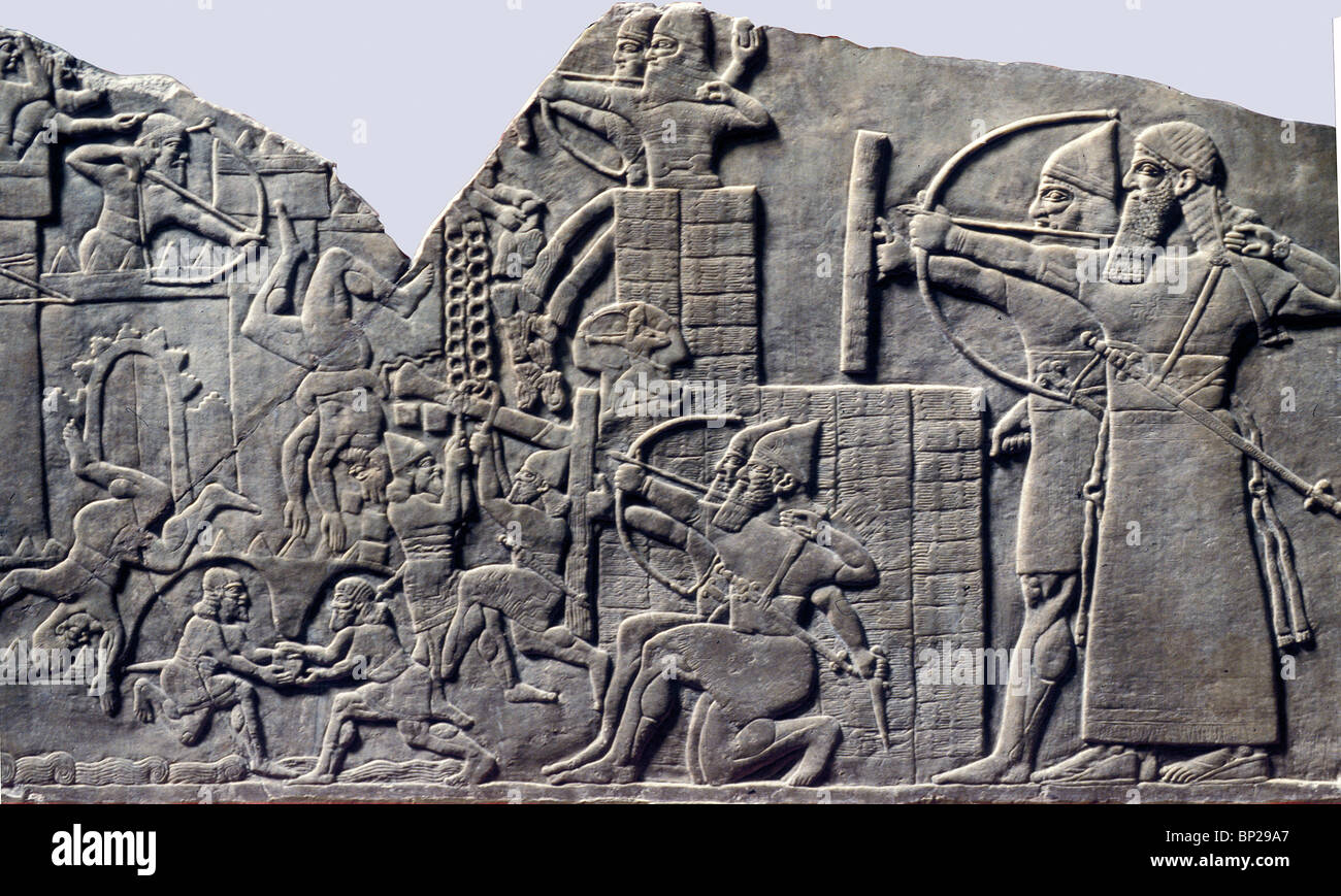 ASSYRIAN ARMY ATTACKING A FORTIFIED CITY. NOTE THE BATTERING RAMIN ACTION & THE ASSYRIAN SOLDIERS TUNNELING THROUGH THE WALL Stock Photo