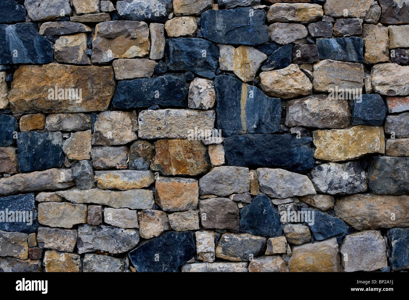 A multi-colored stone wall in rural france Stock Photo