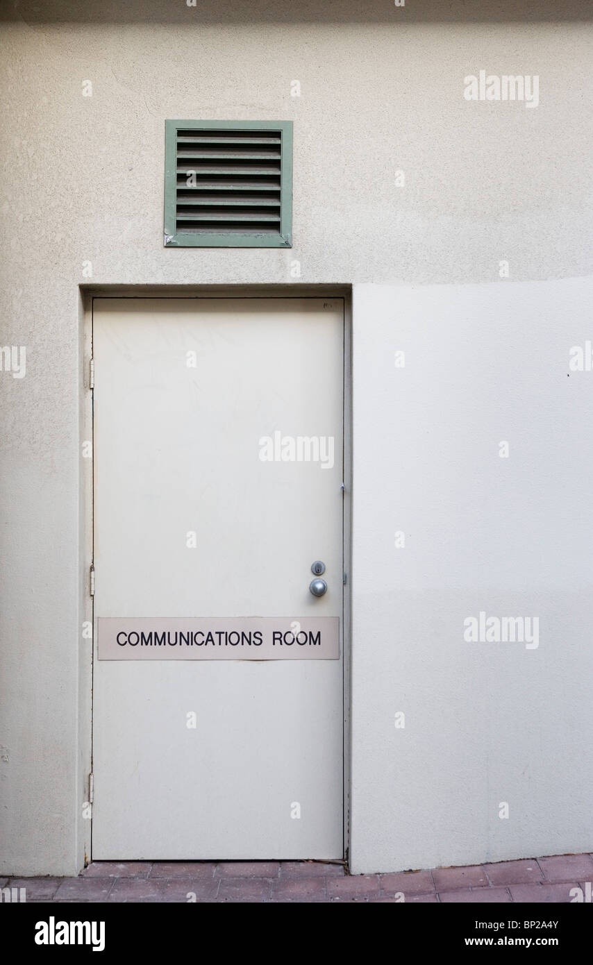 Entrance to a white office block in Manly, Sydney, with a makeshift 'Communications Room' sign on the door. Stock Photo