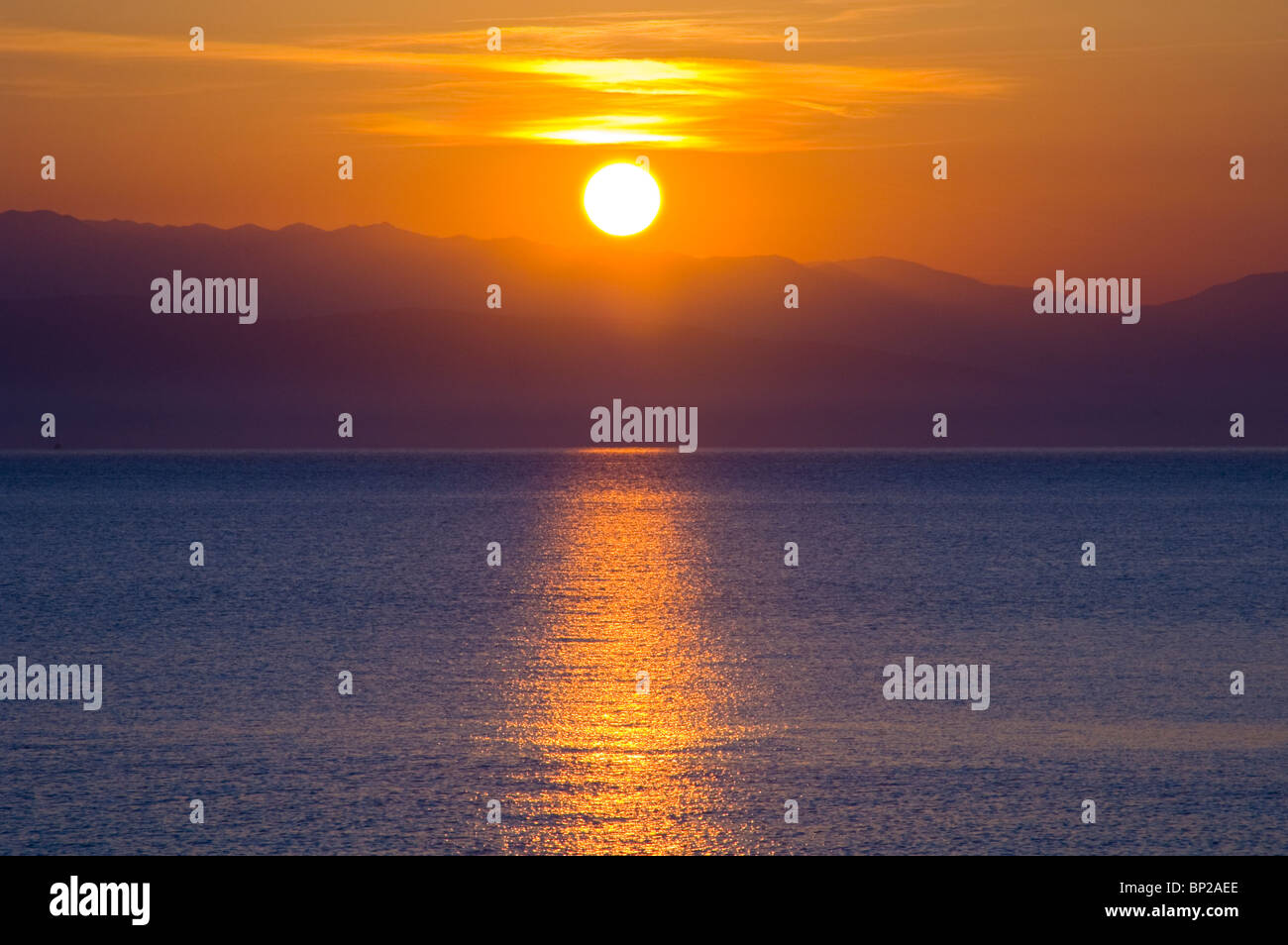 Golden sunrise over the Albanian mountains from Sidari on the Greek island of Corfu Greece GR Stock Photo