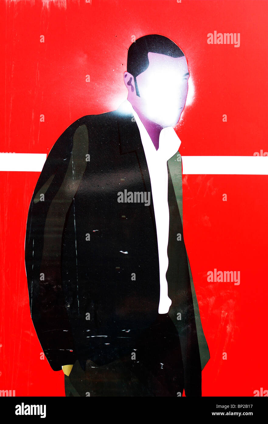 Poster showing a male figure against a red background with the face sprayed over in white paint, London UK. Stock Photo