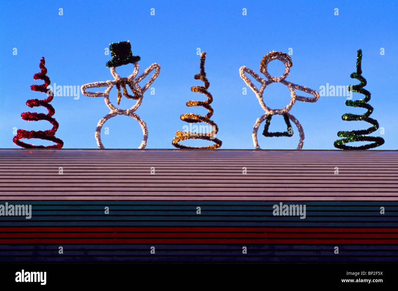 Christmas / Xmas Decorations - Snowman and Snowwoman and Christmas Tree Figures on Roof Stock Photo