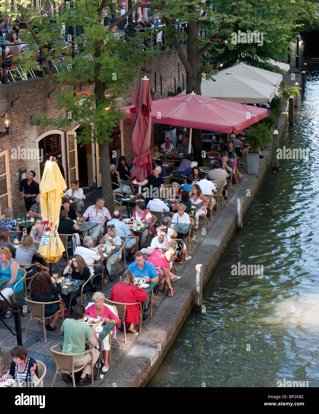Busy outdoor summer cafes and restaurants beside canal Oudegracht in central Utrecht in the