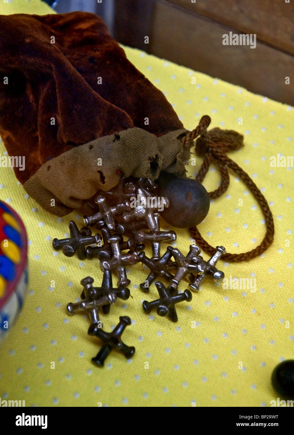 Antique items, a brown draw string pouch with a ball and jacks poured out as the central object. Stock Photo