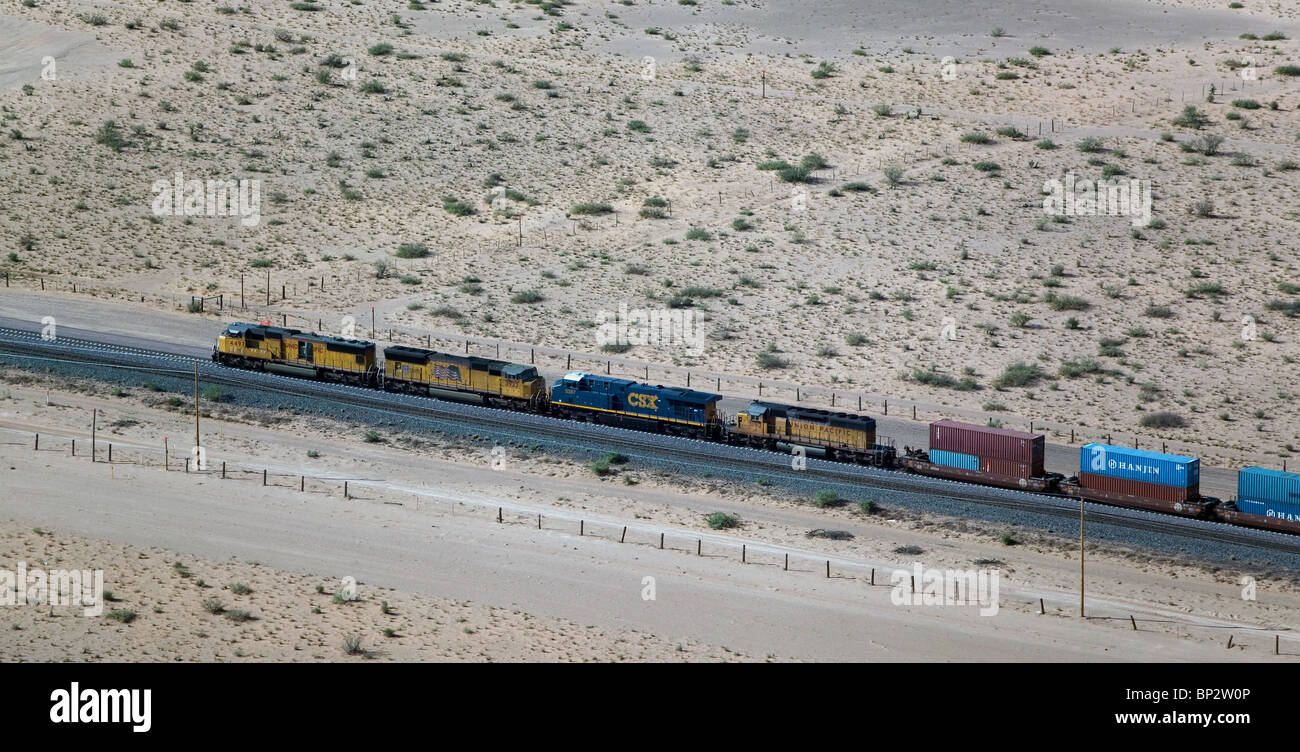 aerial view above freight train passing through desert New Mexico Stock Photo