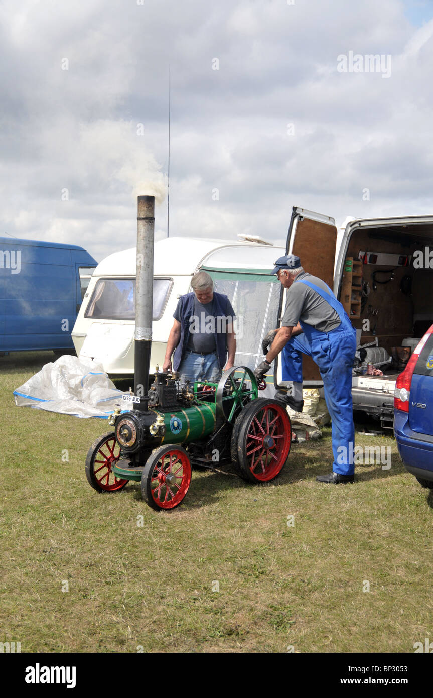 couple of gentlemen tinkering with a steam engine on display at the ...