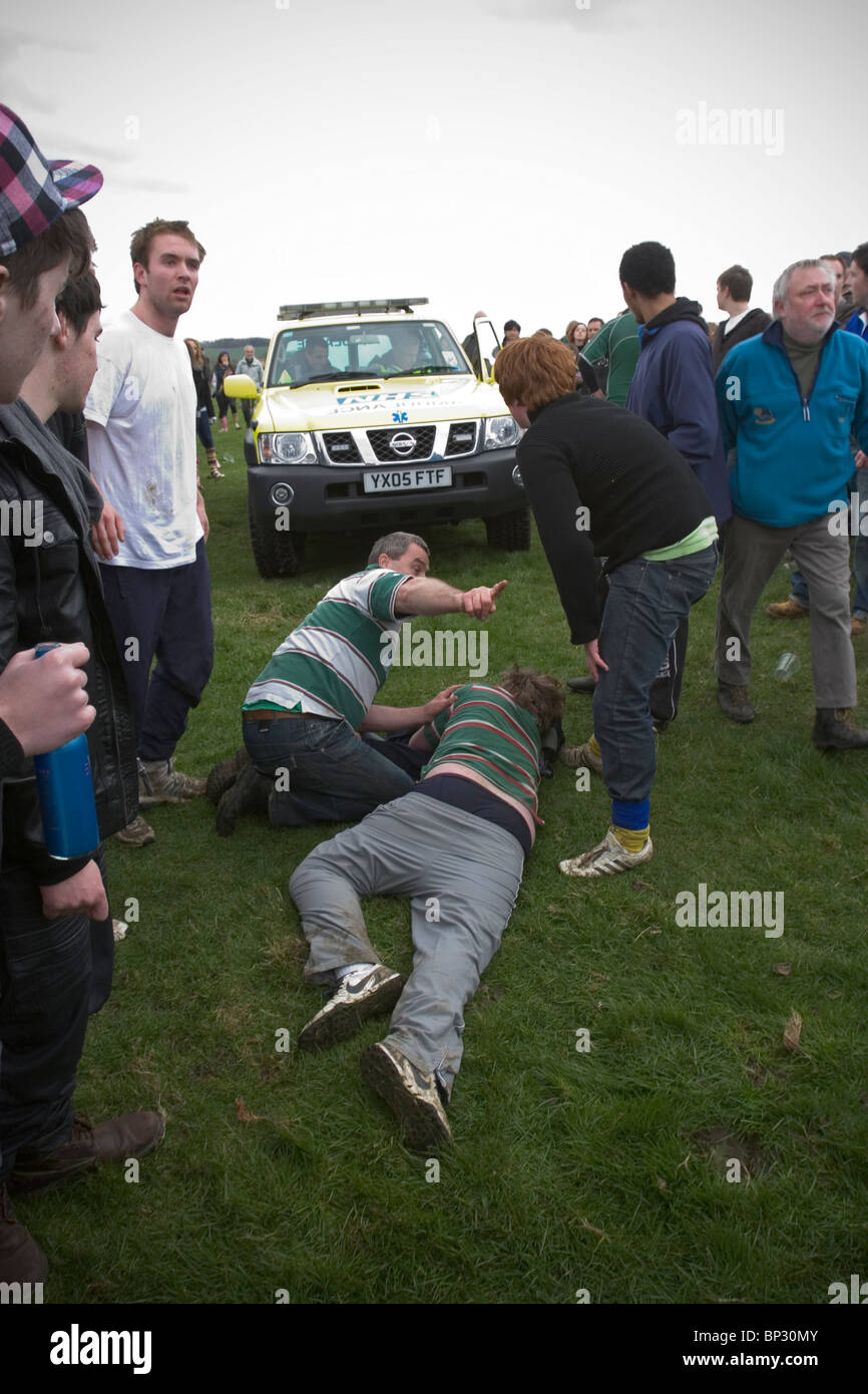 Man lying on floor awaiting medical attention after being trampled during traditional game of Bottlekicking, Leicestershire, UK Stock Photo