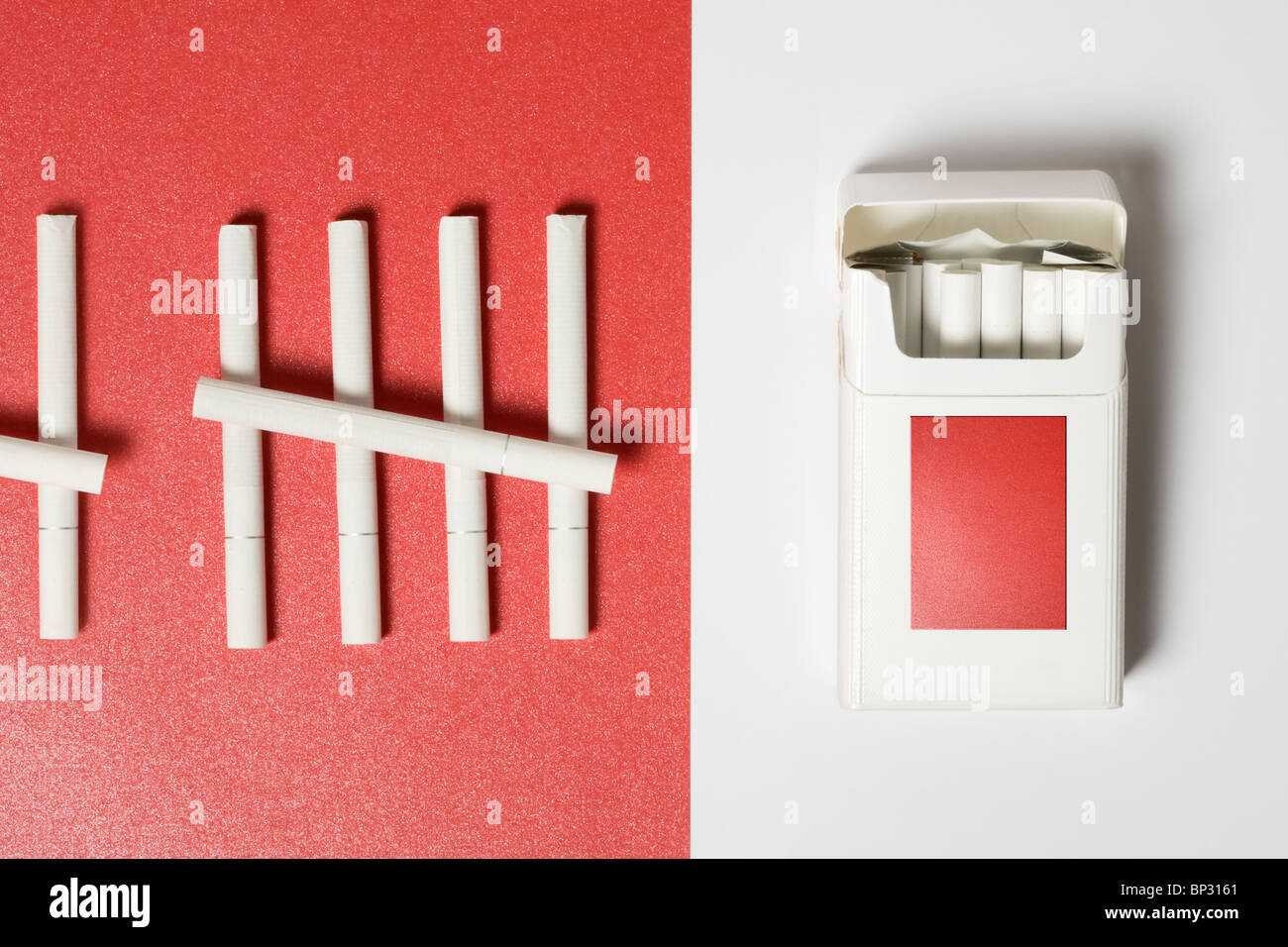 Pack of Cigarettes on white and some cigarettes on red paper background