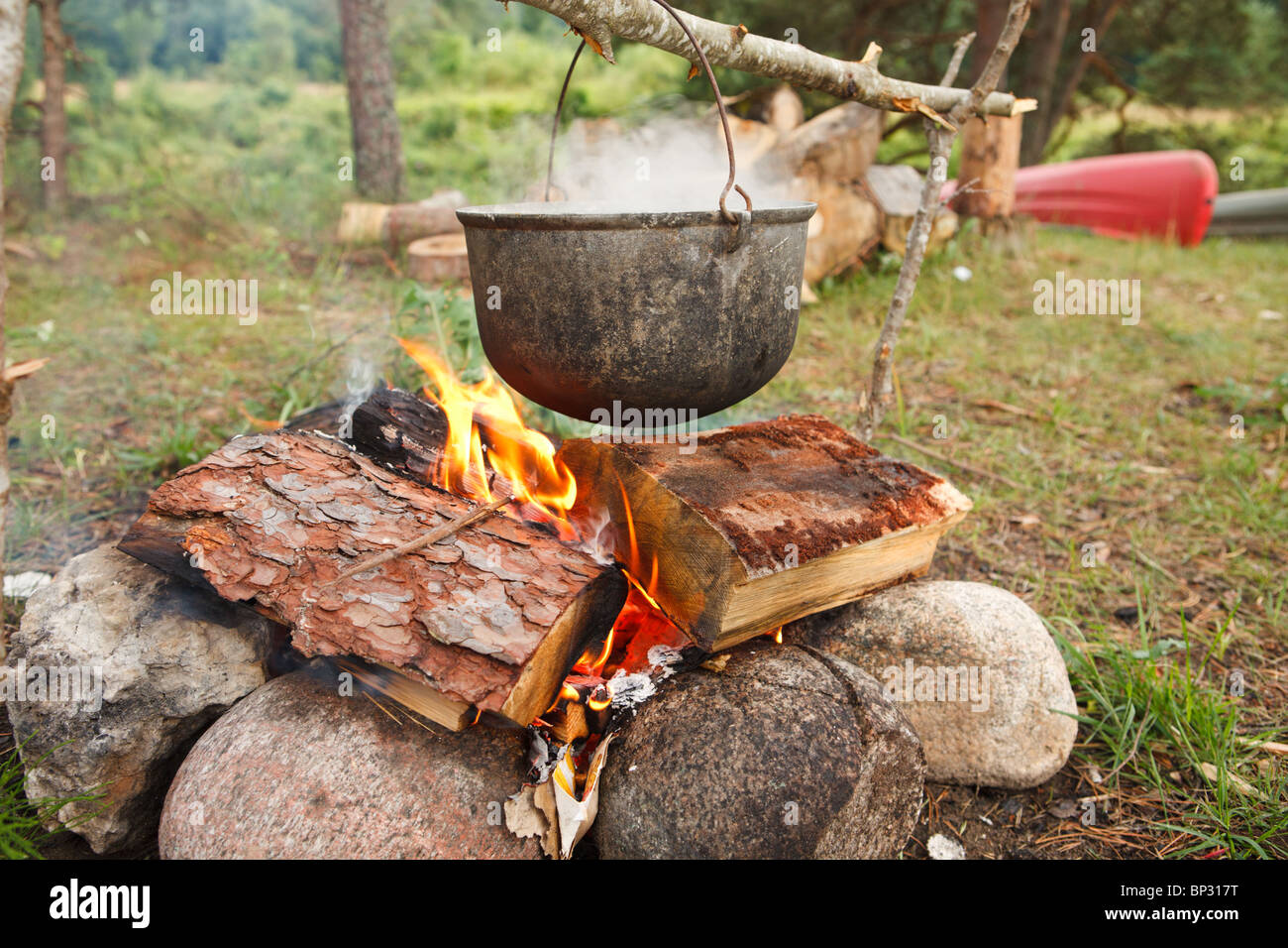 Preparing food on campfire in wild camping Stock Photo - Alamy