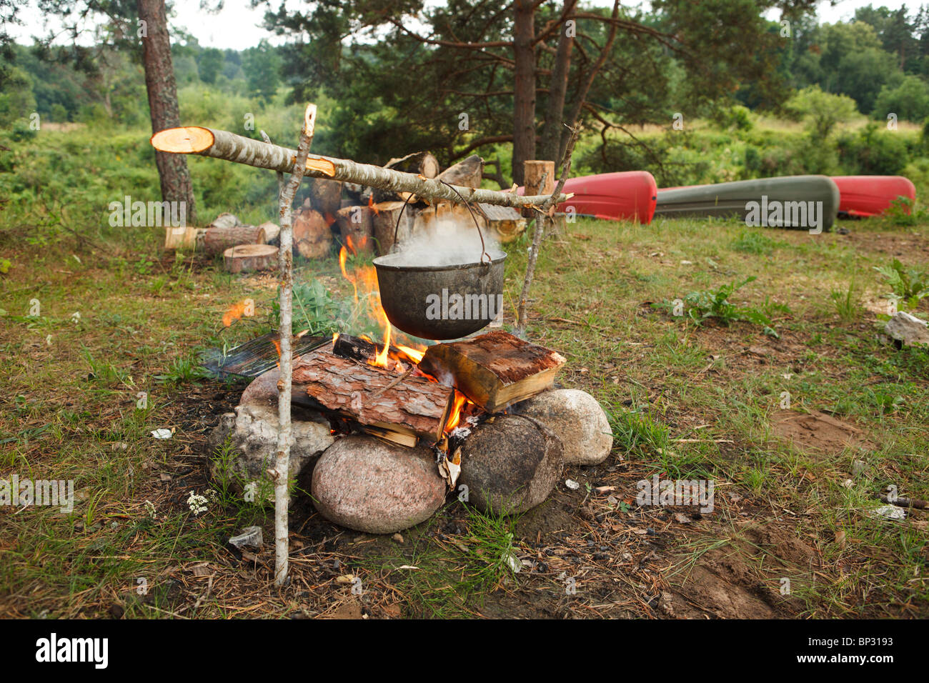 Preparing food on campfire in wild camping Stock Photo - Alamy