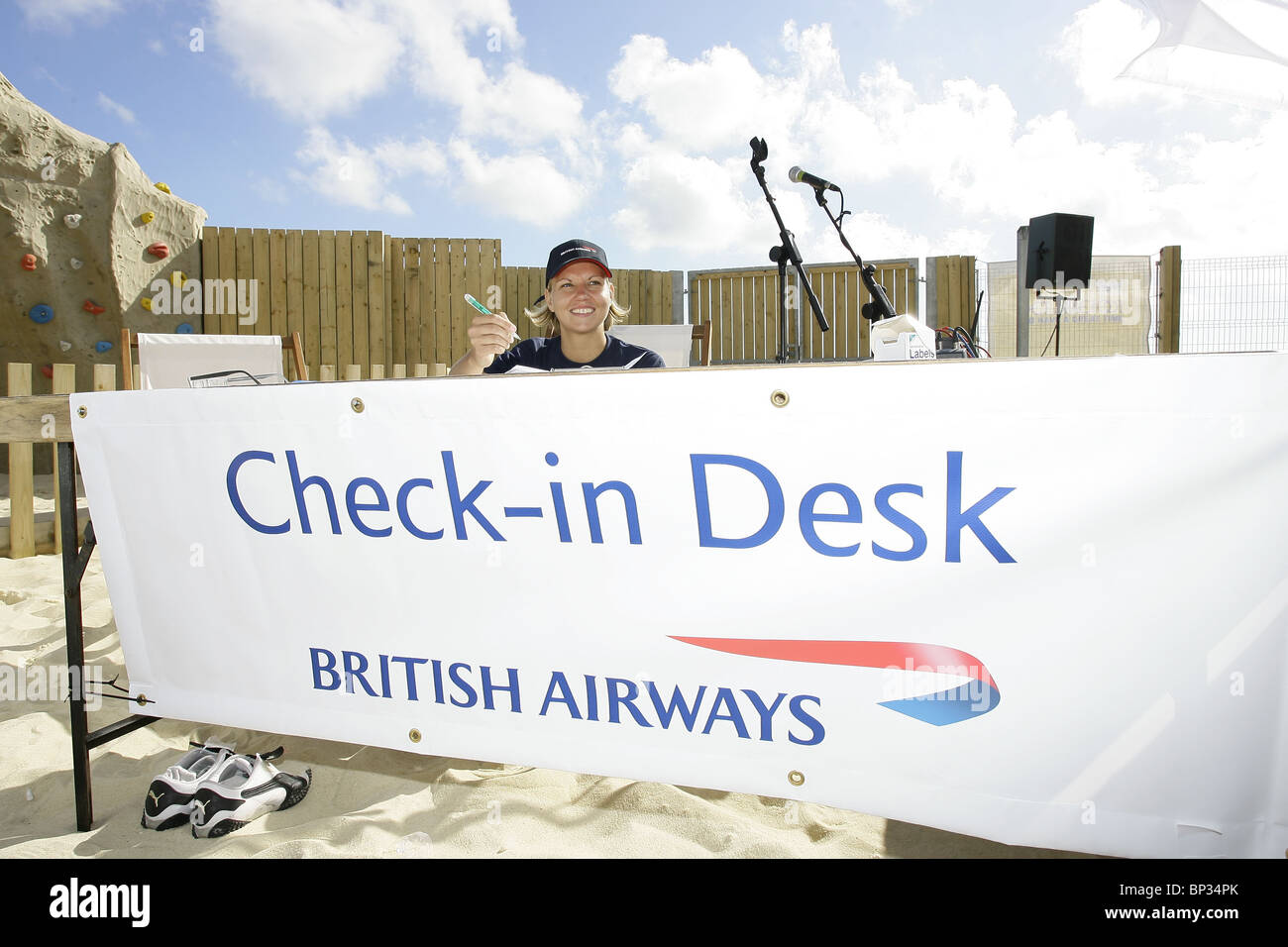 A woman sits at behind a British Airways check in Desk. Picture by James Boardman Stock Photo
