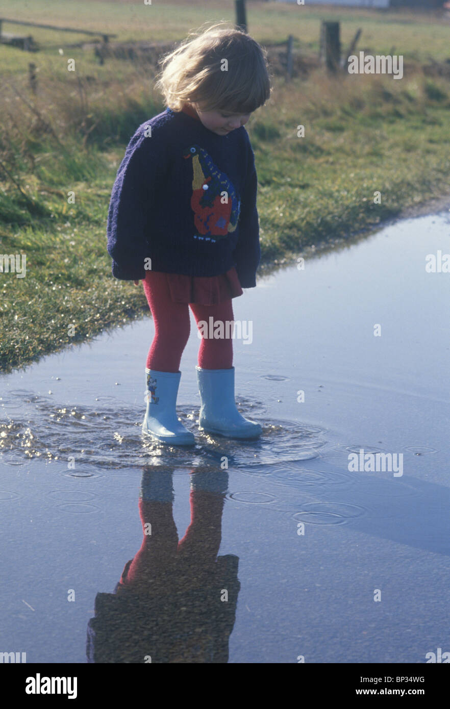 little girl standing in a large puddle Stock Photo