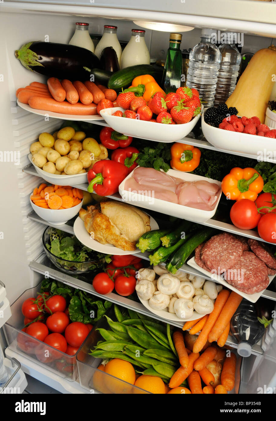 VIEW INSIDE REFRIGERATOR WITH SHELVES FILLED WITH FRESH FOOD Stock Photo