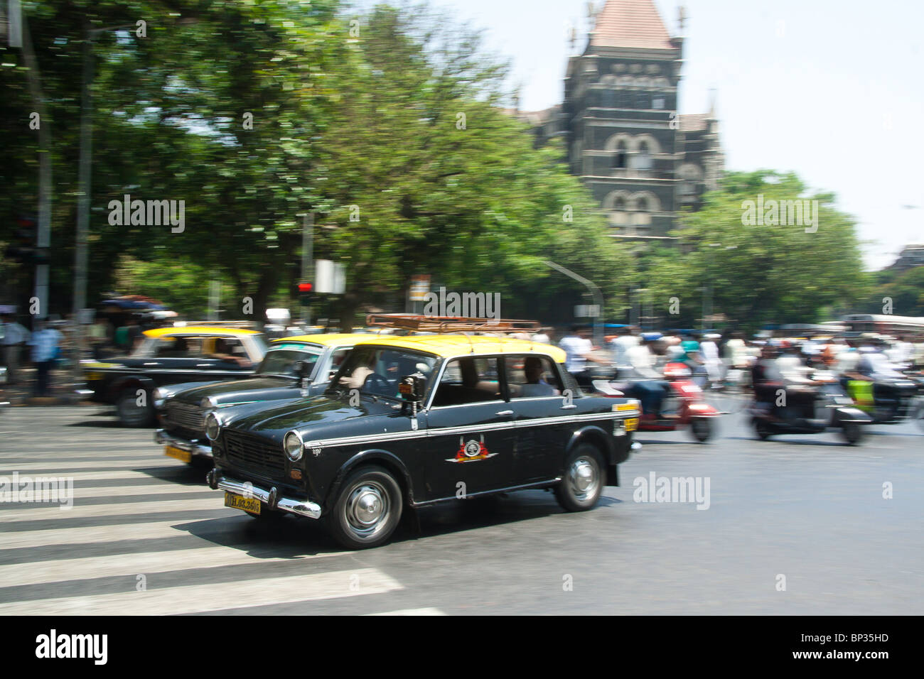 The rush of Mumbai is captured in this energetic shot of taxis shooting by on the street. Stock Photo
