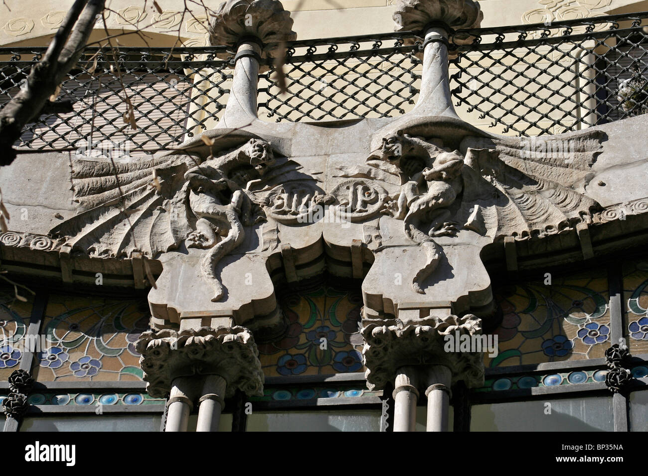 Ornate carved gargoyles forming part of a window frame with floral ...