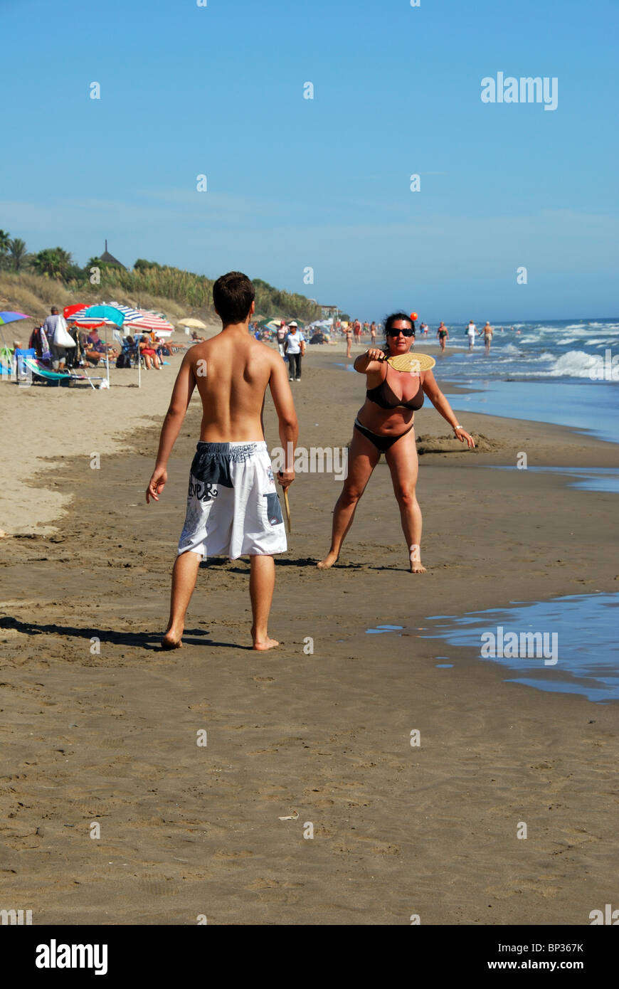 Couple playing a ball game on the beach, Elviria, Marbella, Costa del Sol, Malaga Province, Andalucia, Spain, Western Europe. Stock Photo