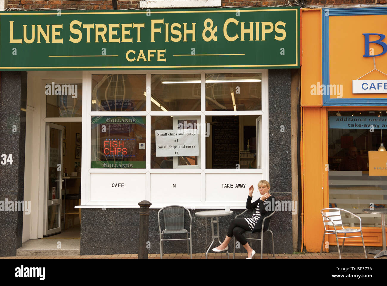 women  smoking at table outside Lune Street fish and Chips Preston city centre Stock Photo