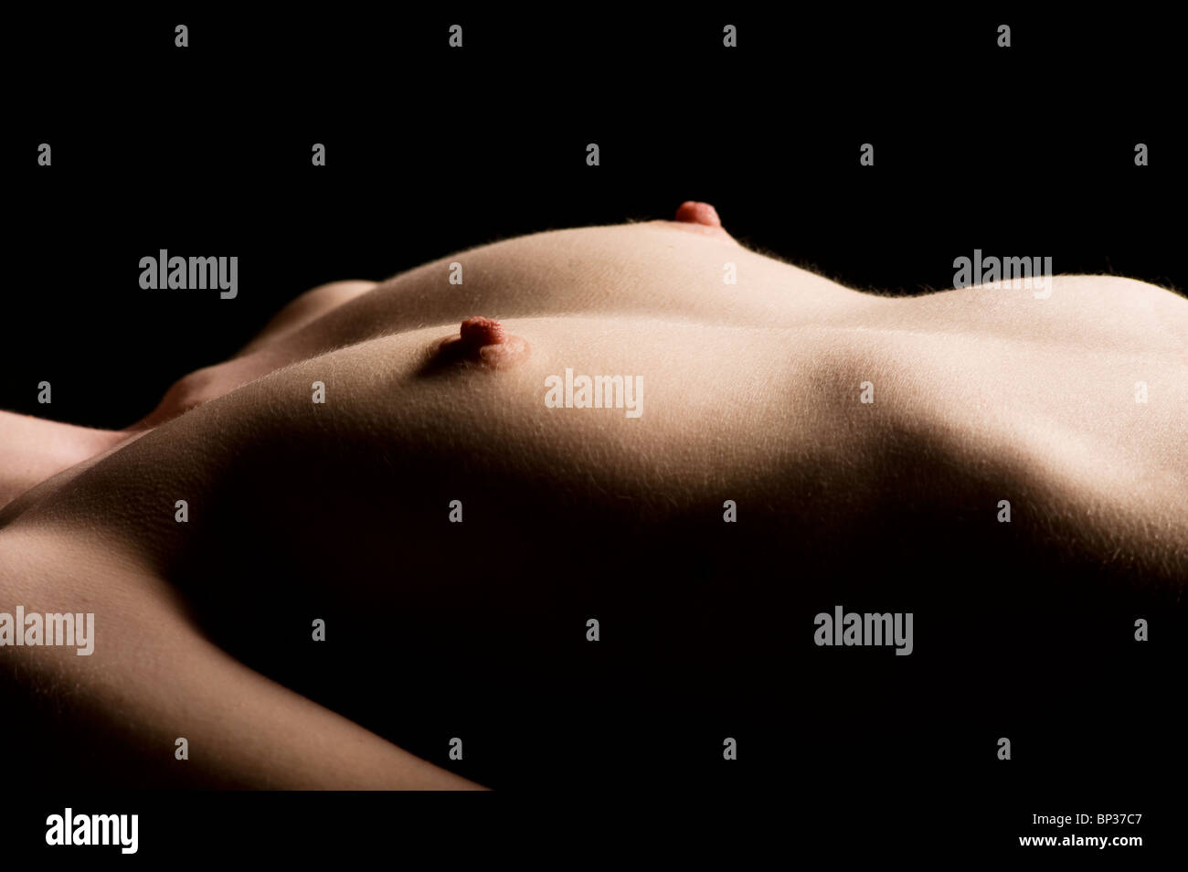 Low key close up studio shot of the breasts of a naked young woman Stock  Photo - Alamy