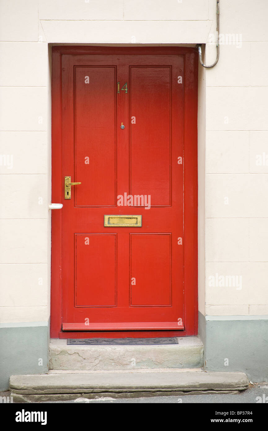 Red painted wooden paneled front door no. 14 with brass handle and