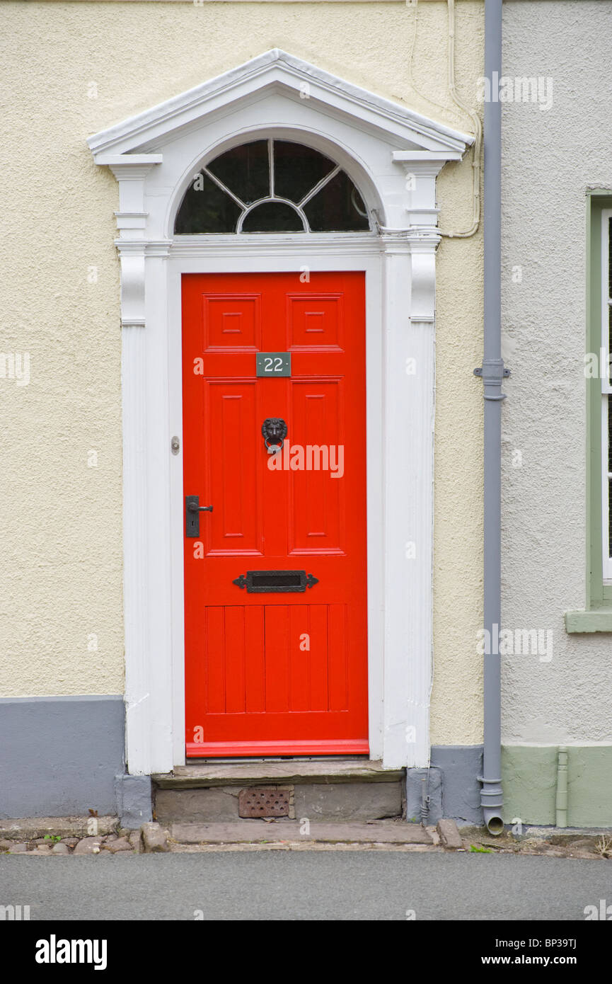 Red painted wooden paneled front door no. 22 with black handle letterbox knocker fanlight Georgian town house in UK Stock Photo