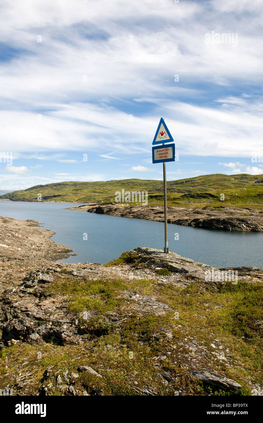 Sign warning of the dangers of swimming in a regulated reservoir. Vikfjell, Norway. Stock Photo