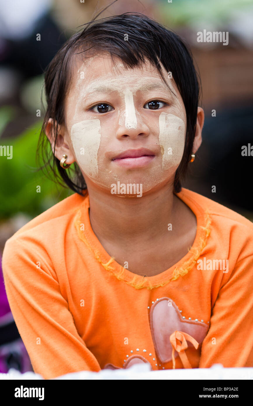 a young Burmese girl wearing tanaka in a central market Stock Photo