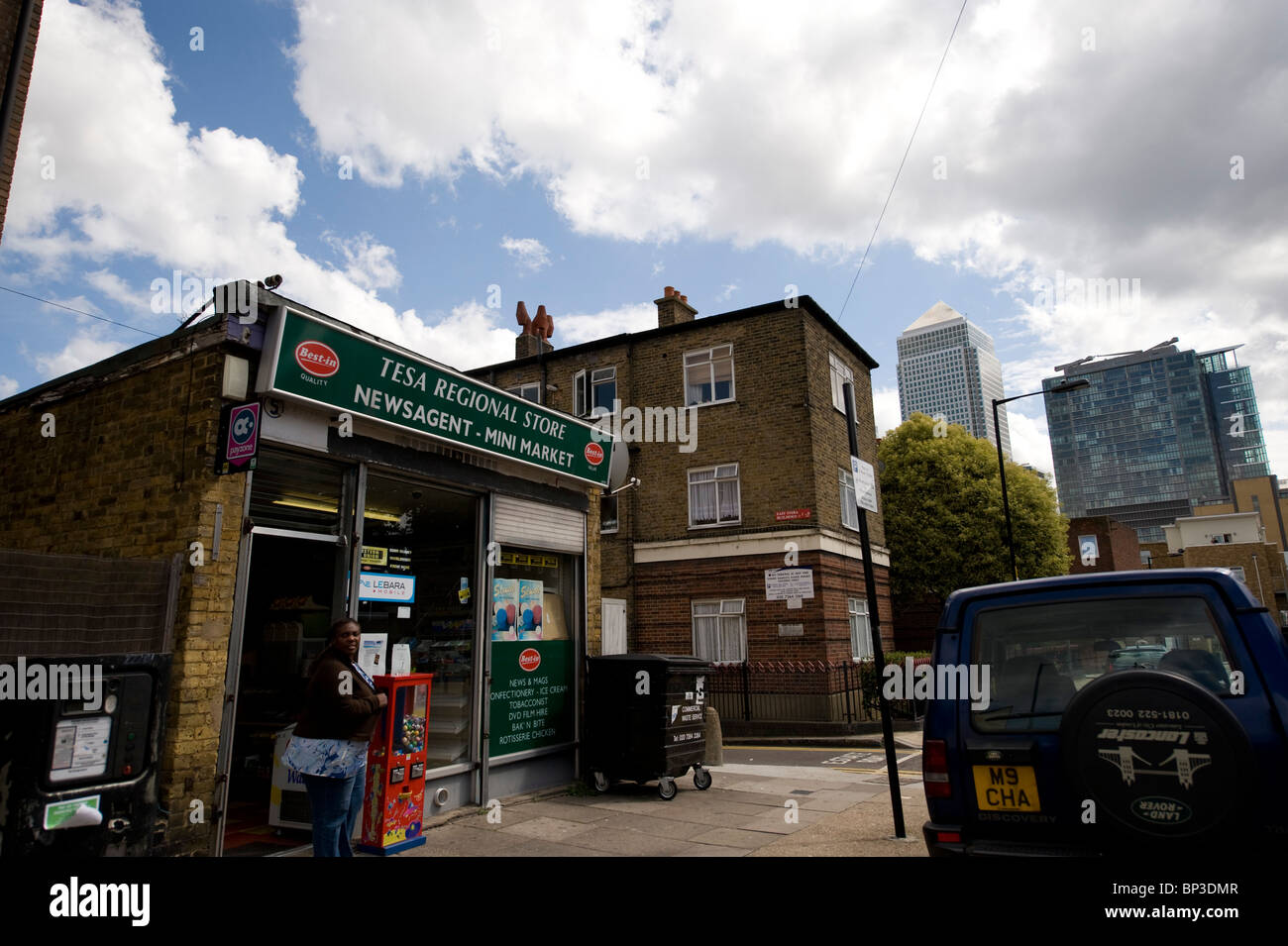Convenient store in a poor area of East London with the richer symbols of the city in the background, such as Canary Wharf Stock Photo