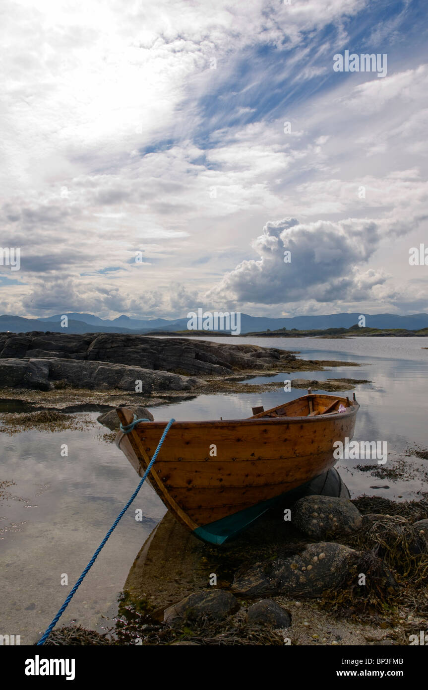 Traditional wooden rowing boat beached on a rocky Island in Norway Stock Photo