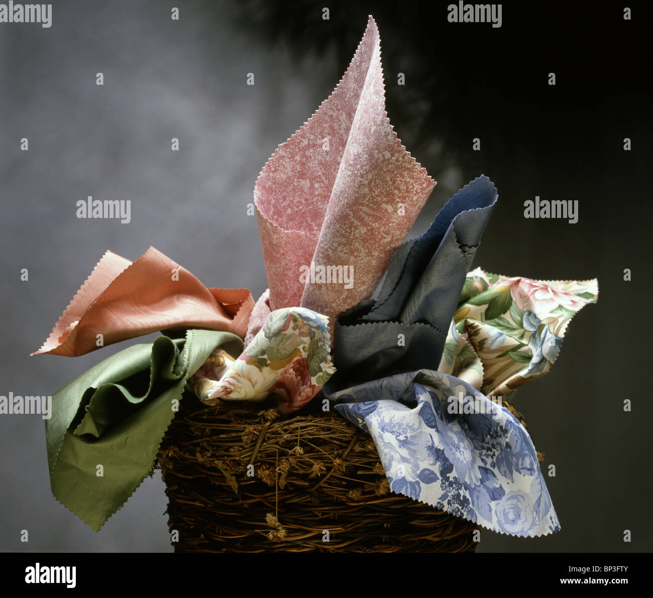 Multi coloured Fabrics in wicker basket Stock Photo Alamy