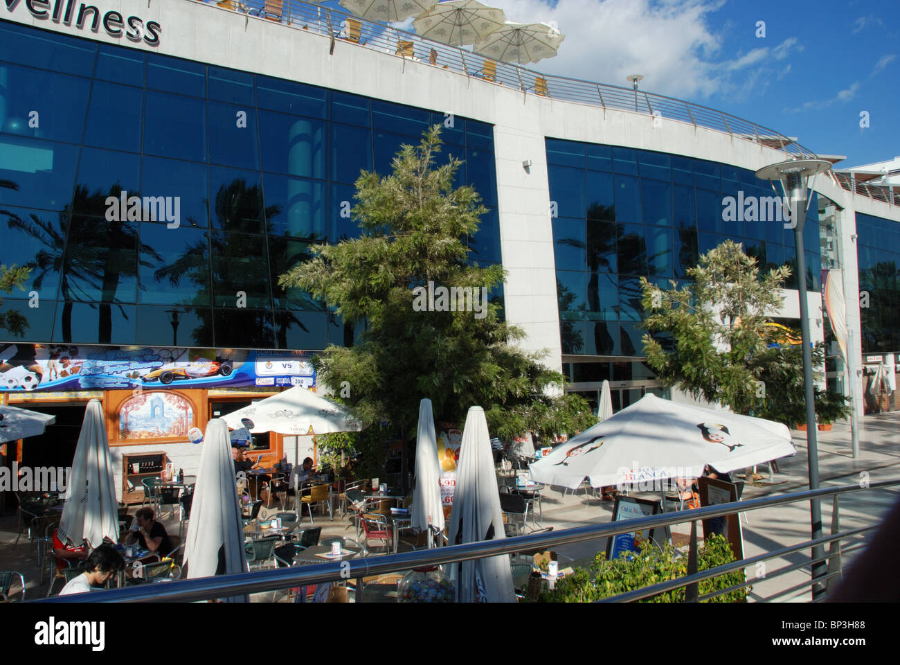 Plaza del Mar shopping centre with cafes in the foreground, Marbella, Costa del Sol, Malaga Province, Andalucia, Spain, Europe. Stock Photo