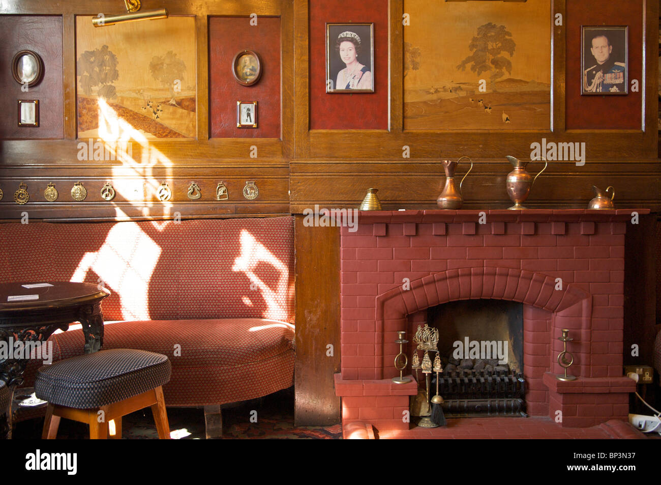 English pub interior showing marquetry panels and sunlight shapes on wall Stock Photo