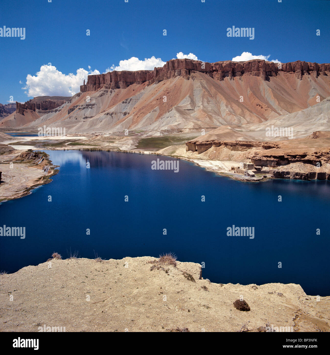 Afghanistan Band-i-Amir Lakes. A small village borders the sapphire waters of the Band-i-Amir Lakes near Bamian in Afghanistan. Stock Photo
