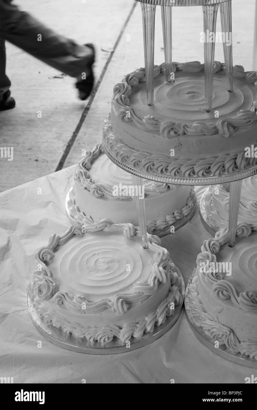 Wedding cake awaits flowers while the cake decorator runs away to get them Stock Photo