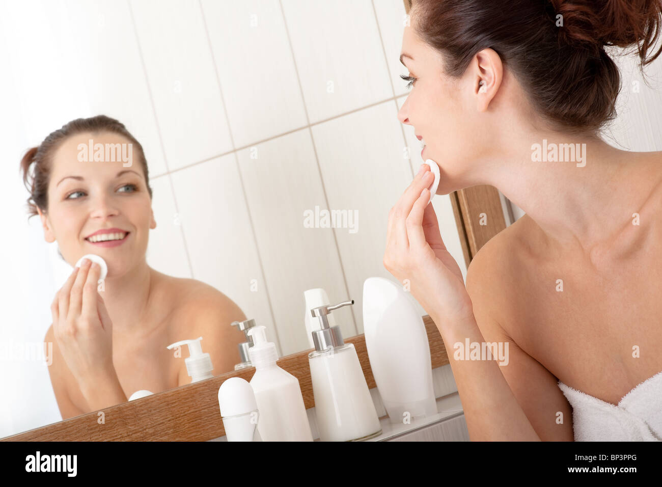 Young woman cleaning her face in the bathroom Stock Photo
