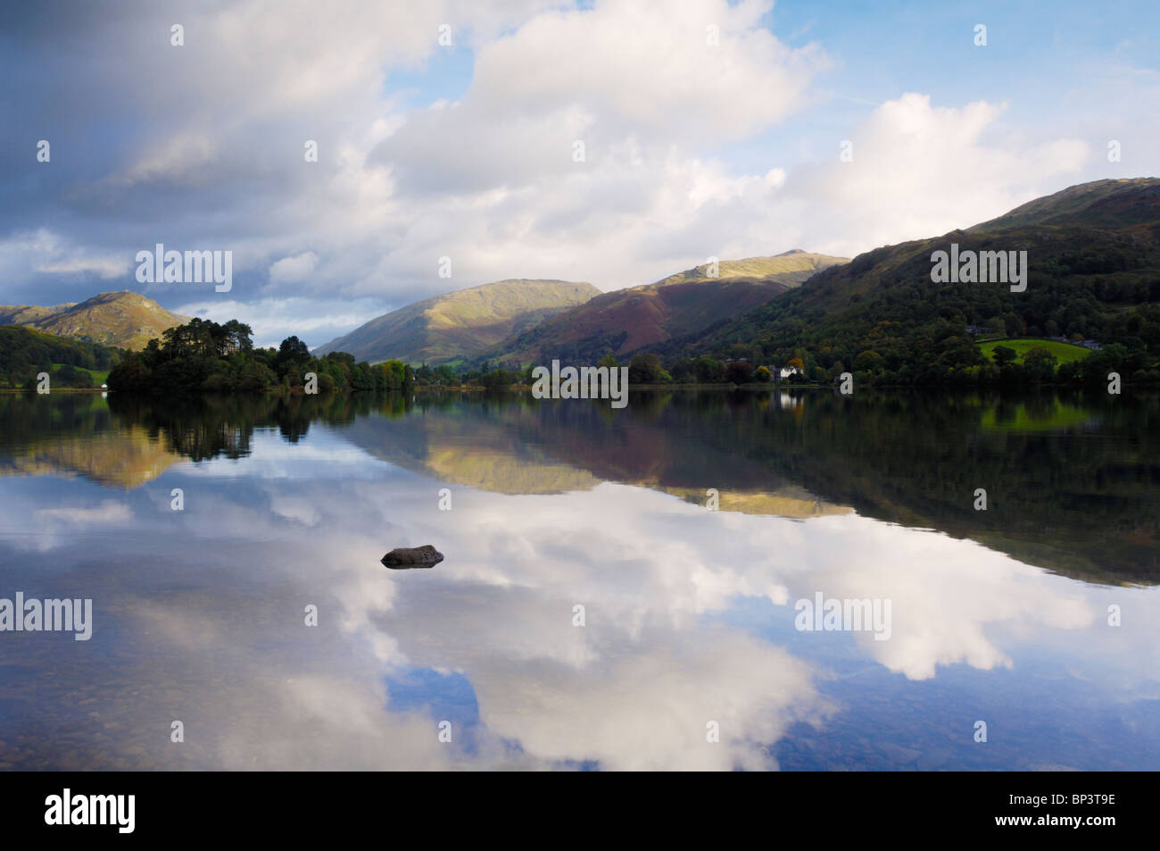 Early morning autumn sun illuminates the mountains at Grasmere in The Lake District National Park Cumbria England. Stock Photo