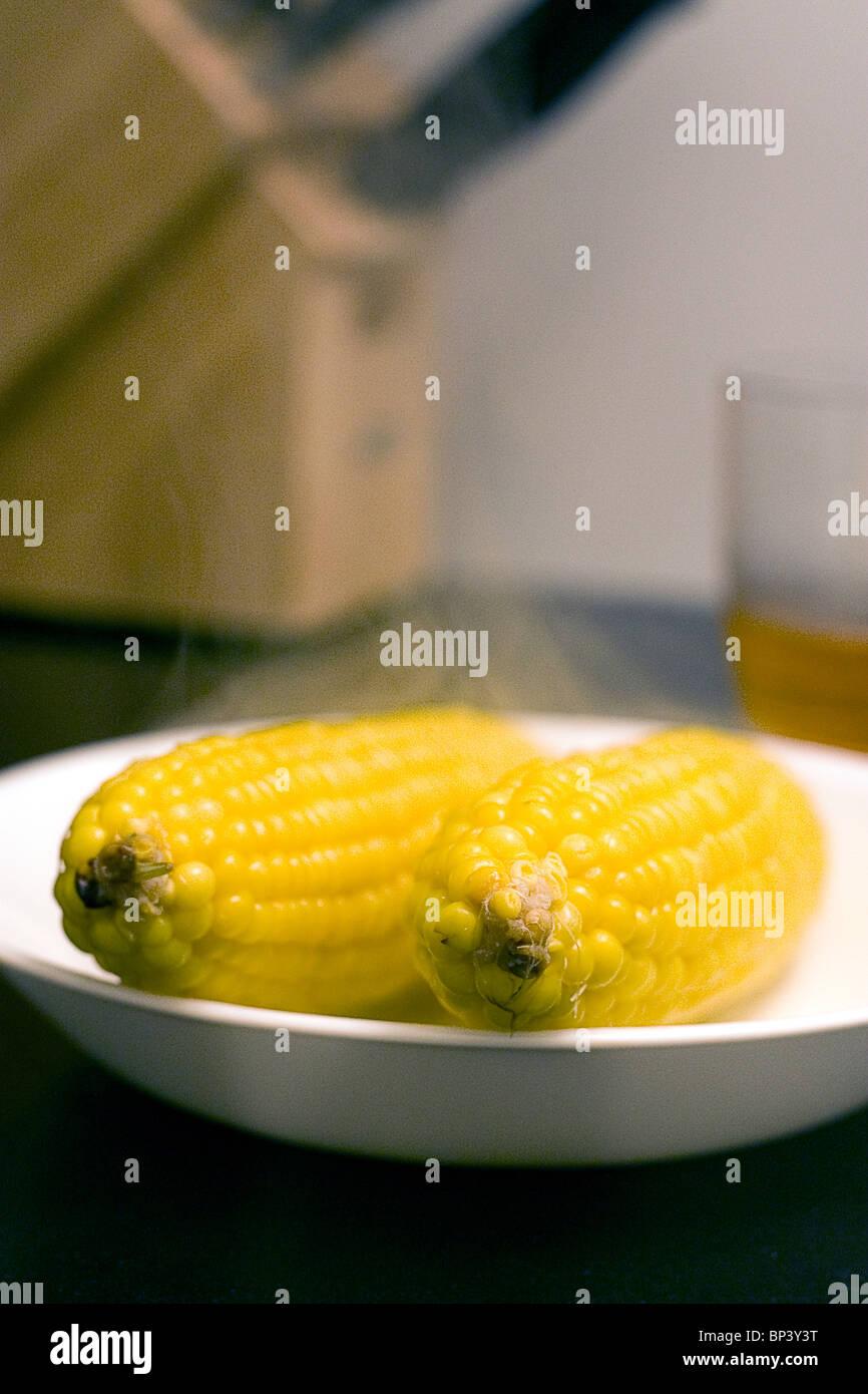 steaming hot corn on the cob in a while bowl on counter Stock Photo